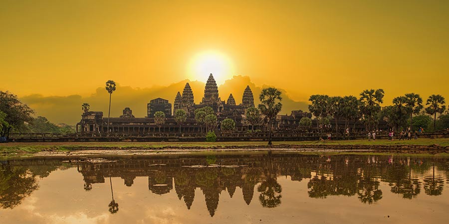 Silhouette of Angkor Wat against a golden sunrise.